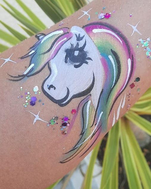 Rainbow unicorn arm painting with gems and stars